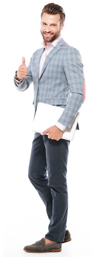Image of smiling young man standing isolated over white background and holding laptop computer. Looking at camera showing thumbs up.